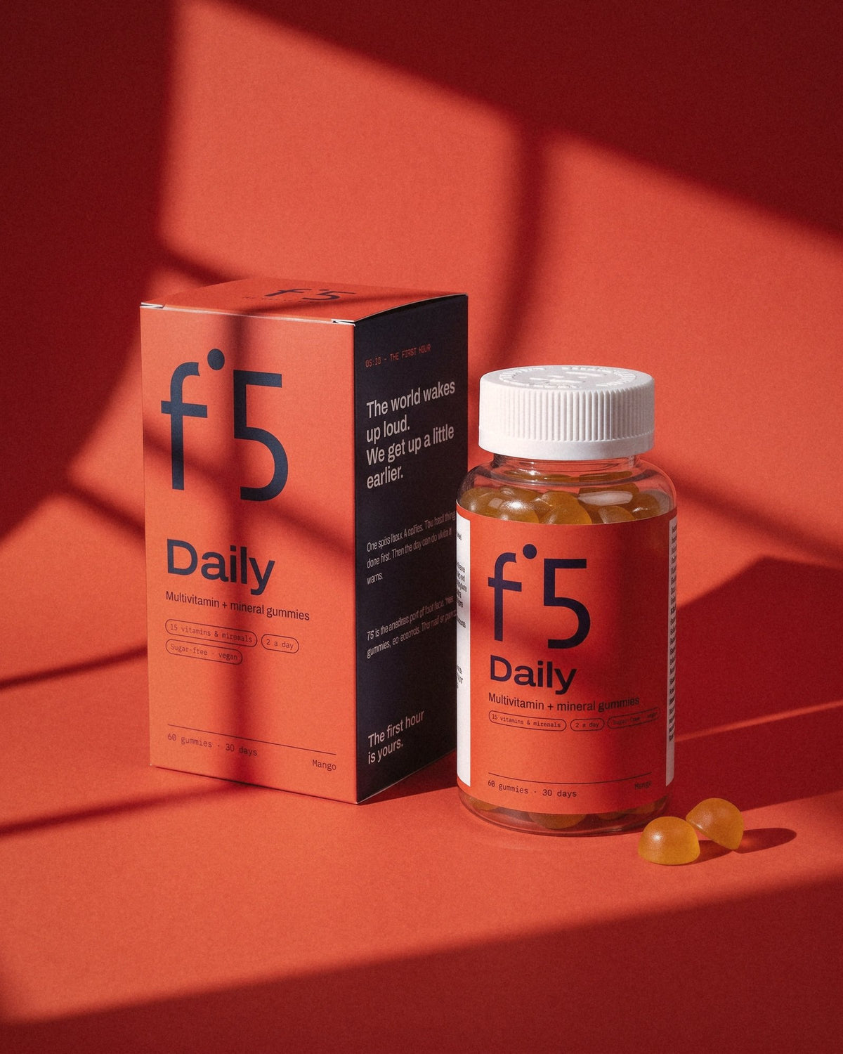 f°5 Daily box and jar with two mango gummies in morning sun